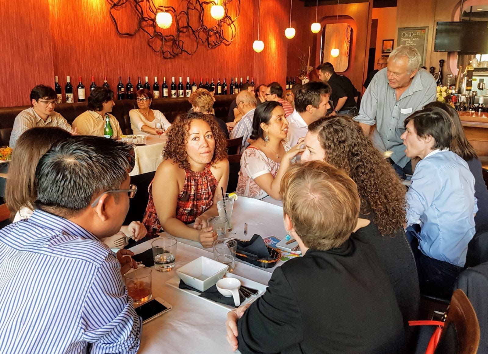 Des membres autour de la table lors d’un dîner French Sunset, juin 2017